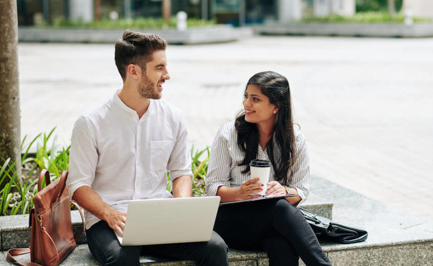 Work colleagues sitting on a bench smiling