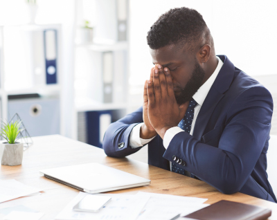 A stressed man working on a laptop