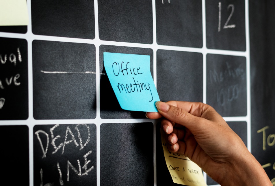 Closeup of a hand moving a sticky note on a visual board