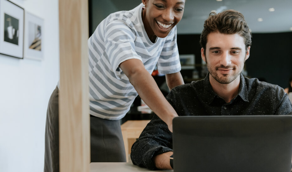 Colleagues are discussing something in front of a laptop