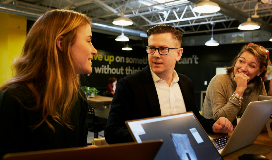Three colleagues discussing work at the office