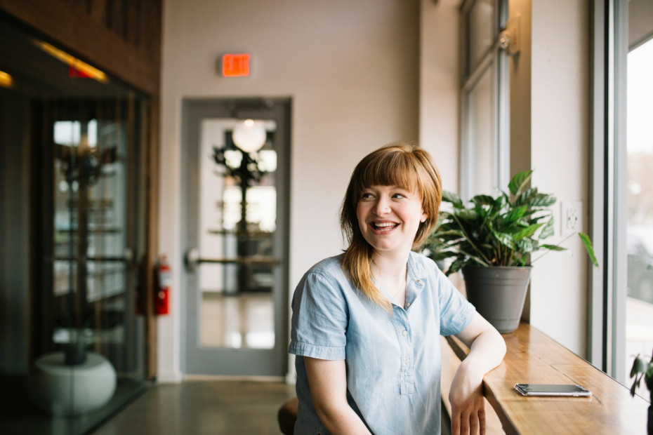 A woman with smartphone is satisifed with her office work