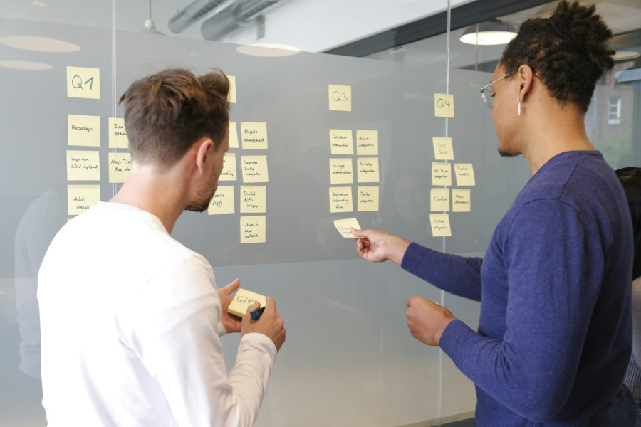 Colleagues working in front of a physical project management board