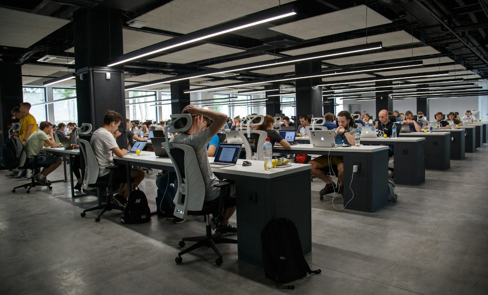 An office packed with people busy on their laptops