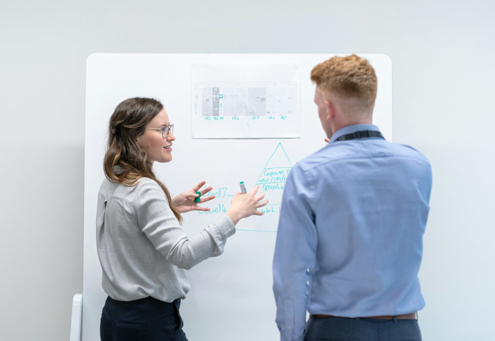 Colleagues working together using a whiteboard