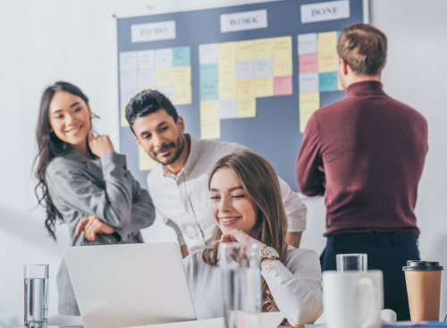 Team works in front of a physical Kanban board