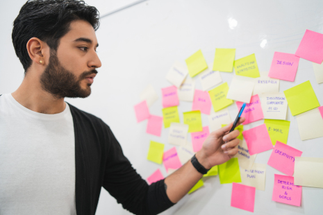 A man working with sticky notes on a whiteboard